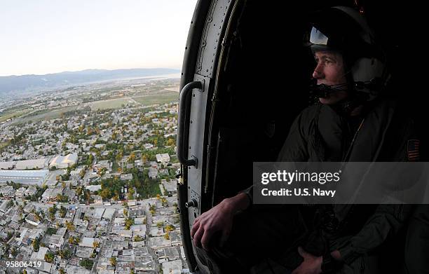 Rear Adm. Ted N. Branch, commander, Carrier Strike Group 1, analyzes the Haitian terrain from an SH-60B Sea Hawk helicopter on January 15, 2009 in...