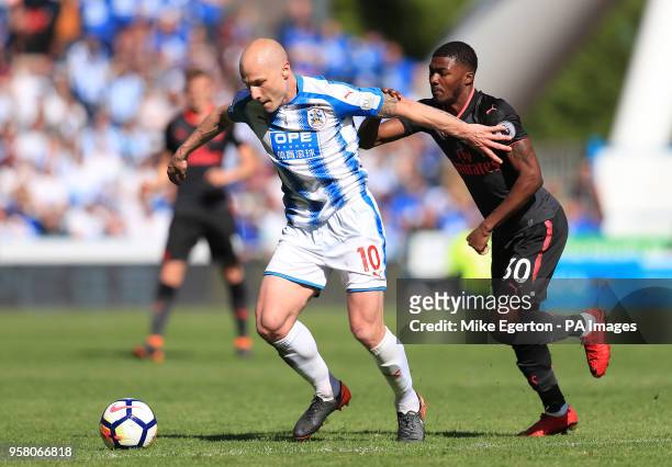 Huddersfield Town's Aaron Mooy and Arsenal's Ainsley Maitland-Niles battle for the ball during the Premier League match at the John Smith's Stadium,...