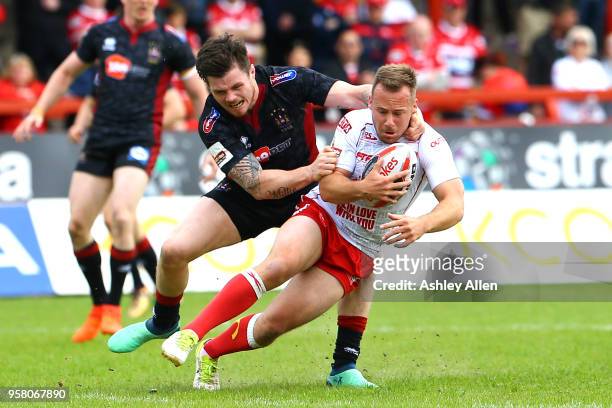 Adam Quinlan of Hull KR is tackled by John Bateman of Wigan Warriors during round six of the Ladbrokes Challenge Cup at KCOM Craven Park on May 13,...