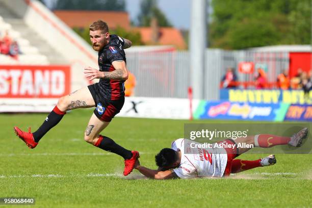 Sam Tomkins of Wigan Warriors gets away from Junior Vaivai of Hull KR during round six of the Ladbrokes Challenge Cup at KCOM Craven Park on May 13,...