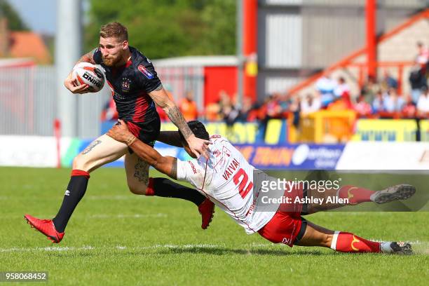 Sam Tomkins of Wigan Warriors gets away from Junior Vaivai of Hull KR during round six of the Ladbrokes Challenge Cup at KCOM Craven Park on May 13,...