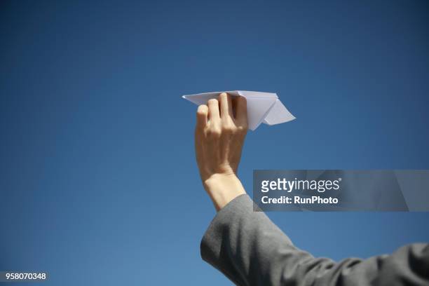 close up of woman holding paper plane toward sky - launching in seoul stock pictures, royalty-free photos & images