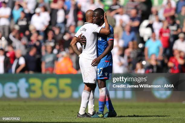 Andre Ayew of Swansea City and Badou Ndiaye of Stoke City hug at full time as both sides drop out of the Premier League during the Premier League...