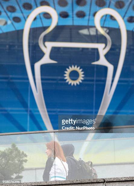 Couple walk near NSC Olimpiyskiy covered with banners for the Champions League in Kyiv, Ukraine, May 13, 2018. Kyiv prepares to host UEFA Women's...