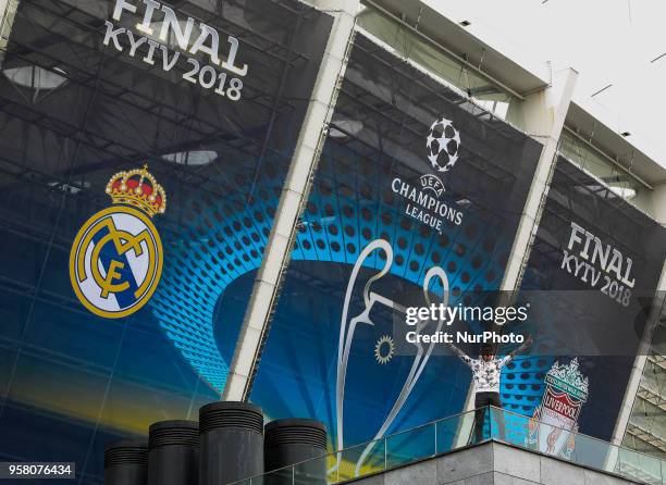 Man poses for a picture in front of NSC Olimpiyskiy covered with banners for the Champions League in Kyiv, Ukraine, May 13, 2018. Kyiv prepares to...