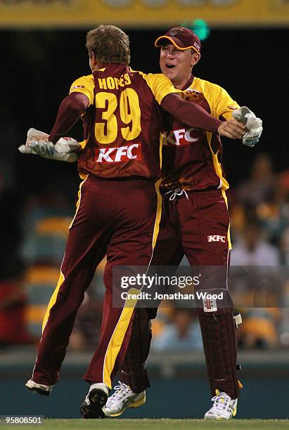 Ben Dunk and James Hopes of the Bulls celebrate after taking a wicket during the Twenty20 Big Bash match between the Queensland Bulls and the Western...