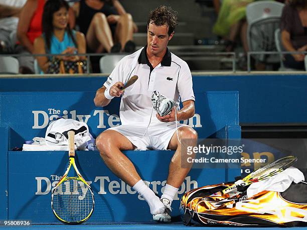 Richard Gasquet of France adjusts his shoe in his men's final against Marcos Baghdatis of Cyprus during day seven of the 2010 Medibank International...