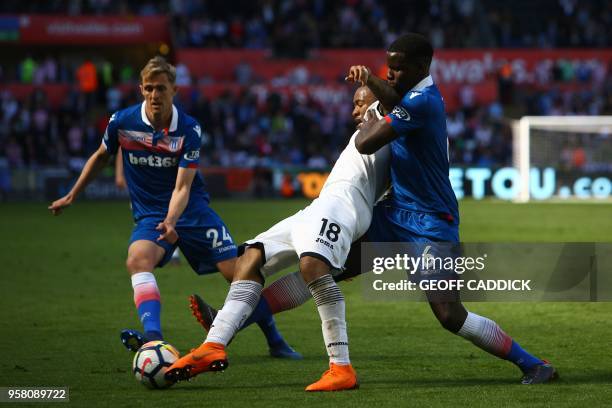 Swansea City's Ghanaian striker Jordan Ayew holds off Stoke City's Scottish midfielder Darren Fletcher and Stoke City's French defender Kurt Zouma...