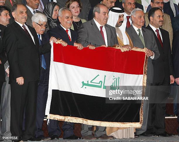 Members of the 'al-Iraqiya Alliance' hold their national flag, from left to right: Sunni lawmaker Saleh al-Mutlak, writer and intellectual Shiite...