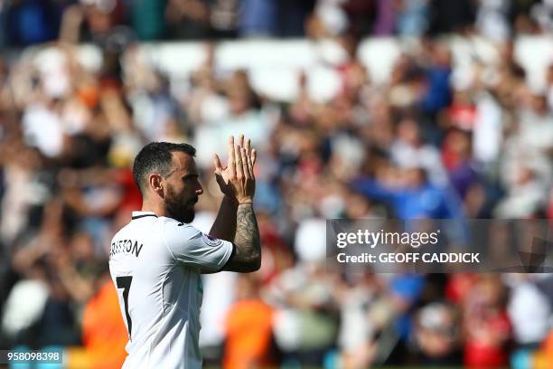 Swansea City's English midfielder Leon Britton applauds the fans after losing the English Premier League football match between Swansea City and...
