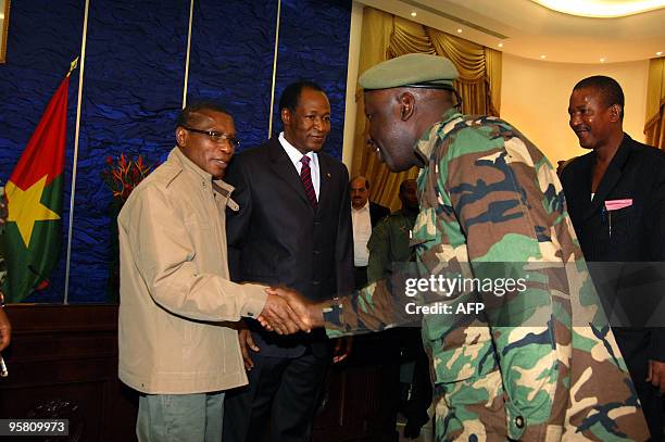 Guinean junta chief Captain Moussa Dadis Camara shake hands with an unidentified officer as Burkina Faso's President Blaise Campaore looks on on...
