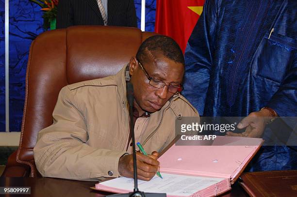 Guinean junta chief Captain Moussa Dadis Camara signs a pact on Januray 15, 2010 in Ouagadougou during a meeting with interim junta chief General...