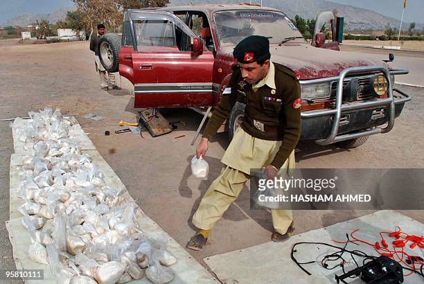 Pakistani frontier constable removes explosive materials defused from a four-wheel drive vehicle seized during a search operation in Bara on January...