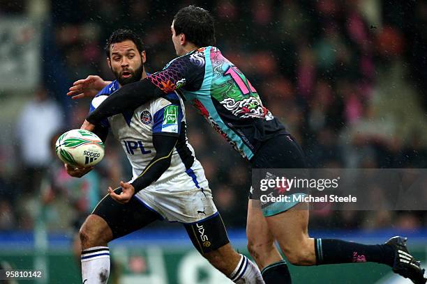 Joe Maddock of Bath feeds a pass as Geoffroy Messina closes in during the Stade Francais v Bath Heineken Cup Pool 4 match at the Stade Jean Bouin on...