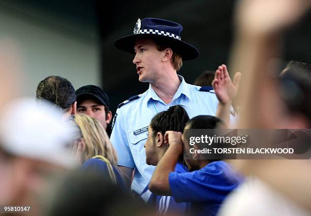 An Australian policeman stands within the crowd during a match at the Australian Open tennis tournament in Melbourne, 15 January 2008. Police...