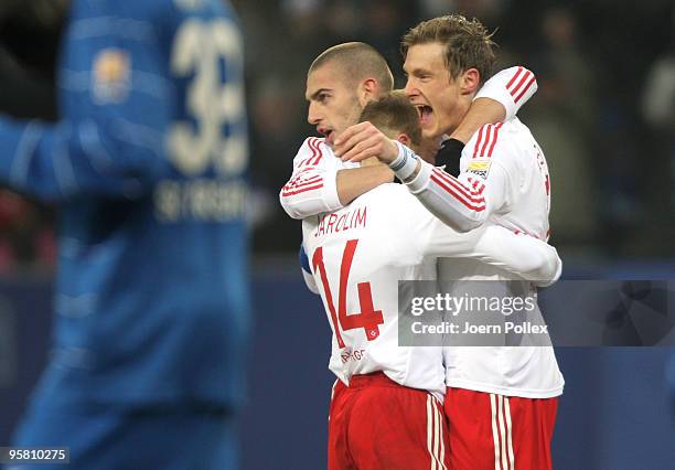 Marcell Jansen of Hamburg celebrates with his team mates David Jarolim and Mladen Petric after scoring his team's first goal during the Bundesliga...
