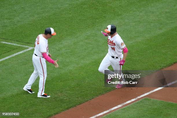 Third base coach Bobby Dickerson congratulates Trey Mancini of the Baltimore Orioles after hitting a solo home run in the second inning against the...