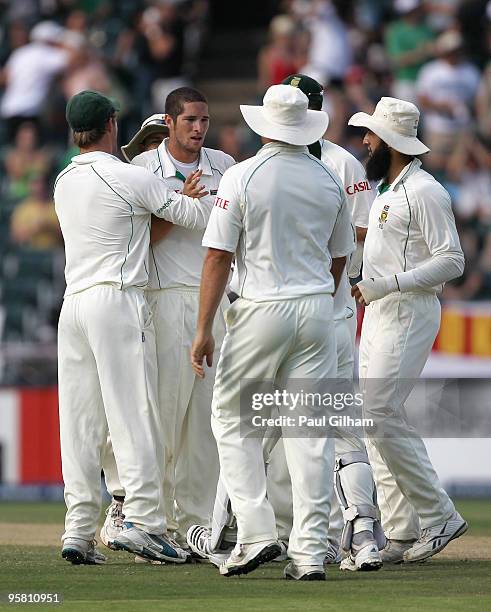 Wayne Parnell of South Africa celebrates with his team-mates after taking the wicket of Andrew Strauss of England for lbw and 22 runs during day...