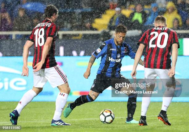 Alejandro Dario Gomez of Atalanta BC competes for the ball with Ignazio Abate and Riccardo Montolivo of AC Milan during the serie A match between...