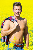 handsome blond man standing in a yellow field