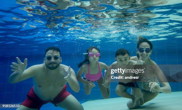 retrato de familia dulce sonriendo a la cámara bajo el agua - funny water fotografías e imágenes de stock