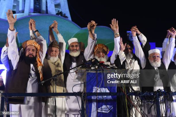 Leaders of Muttahida Majlis-e-Amal , a religious parties alliance, raise hands in solidarity during a public meeting in Lahore, on May 13 in the...