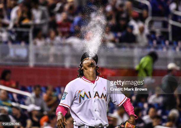 Jose Urena of the Miami Marlins sprays water before heading to the mound to pitch in the third inning against the Atlanta Braves at Marlins Park on...