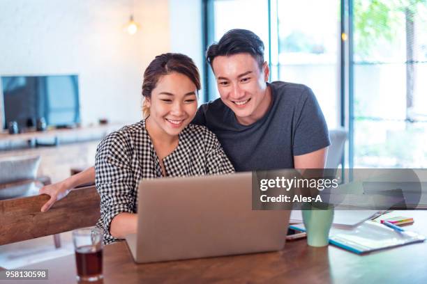 young asian couple at home - chinese people on computer stock pictures, royalty-free photos & images
