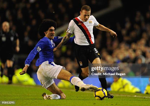 Marouane Fellaini of Everton tackles Craig Bellamy of Manchester City during the Barclays Premier League match between Everton and Manchester City at...