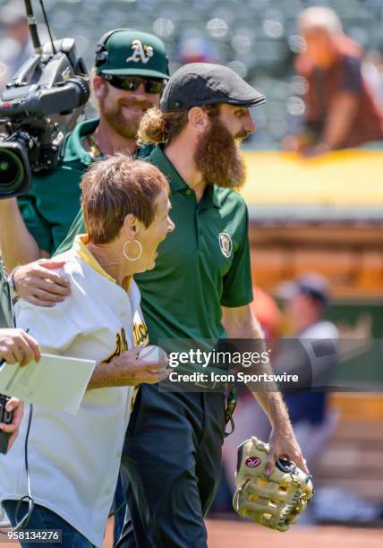 Peggy Lindsey, grandmother to Dallas Braden gets a signed ball from Braden before the game between the Houston Astros vs Oakland Athletics on...