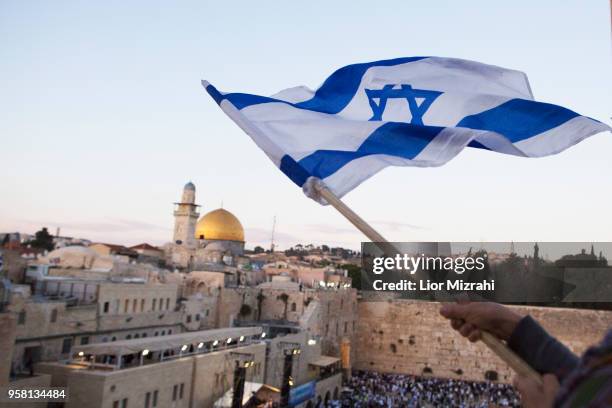 Israelis wave their national flags during a march next to the Western Wall on May 13, 2018 in Jerusalem, Israel. Israel mark Jerusalem Day...