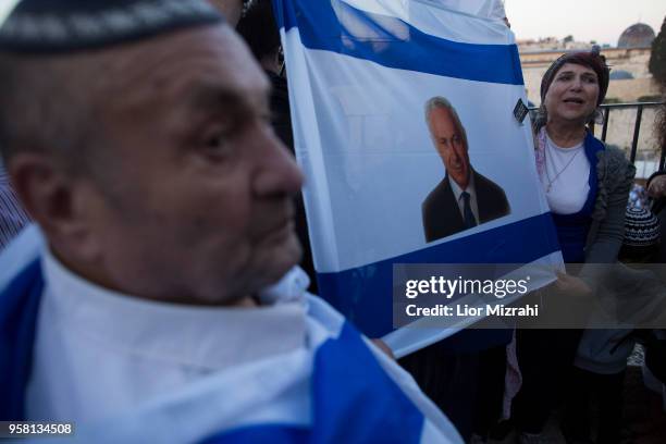 Israelis hold an Israeli flag with an image of Israeli Prime Minister Benjamin Netanyahu next to the Western Wall on May 13, 2018 in Jerusalem,...