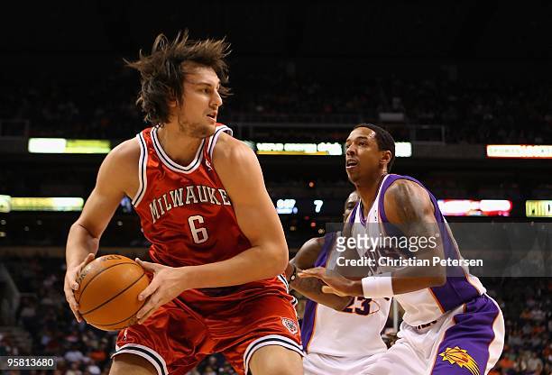 Andrew Bogut of the Milwaukee Bucks handles the ball under pressure from Channing Frye of the Phoenix Suns during the NBA game at US Airways Center...