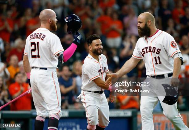 Evan Gattis of the Houston Astros is congratulated by Jose Altuve and Derek Fisher after hitting a two-run home run in the third inning against the...