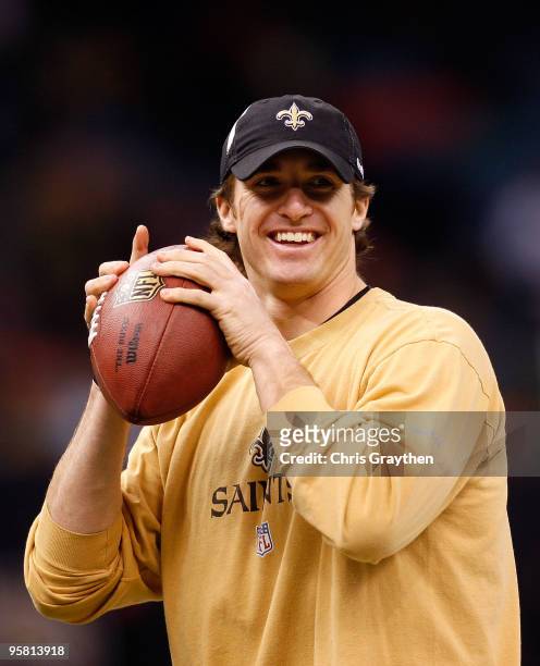 Quarterback Drew Brees of the New Orleans Saints smiles as he warms up against the Arizona Cardinals during the NFC Divisional Playoff Game at...