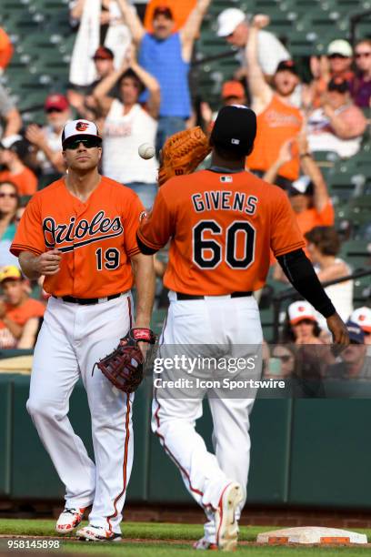 Baltimore Orioles relief pitcher Mychal Givens tosses the ball to first baseman Chris Davis to end the game between the Tampa Bay Rays and the...