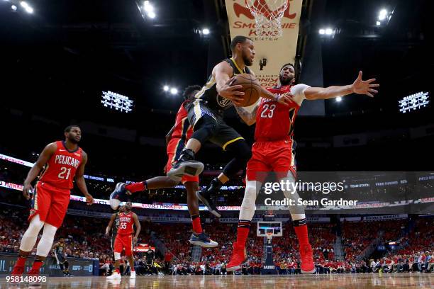 Stephen Curry of the Golden State Warriors passes the ball around Anthony Davis of the New Orleans Pelicans during Game Four of the Western...