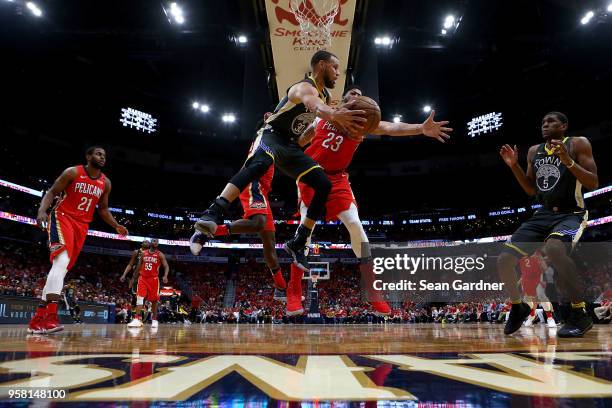 Stephen Curry of the Golden State Warriors passes the ball around Anthony Davis of the New Orleans Pelicans during Game Four of the Western...