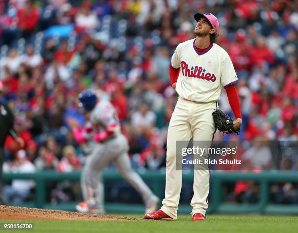 Pitcher Aaron Nola of the Philadelphia Phillies looks out as Yoenis Cespedes of the New York Mets rounds first base after hitting a home run in the...