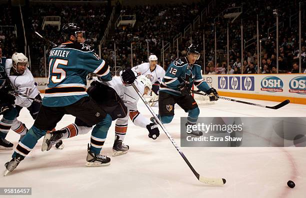 Dany Heatley and Patrick Marleau of the San Jose Sharks and Ladislav Smid of the Edmonton Oilers go for the puck at HP Pavilion on January 16, 2010...