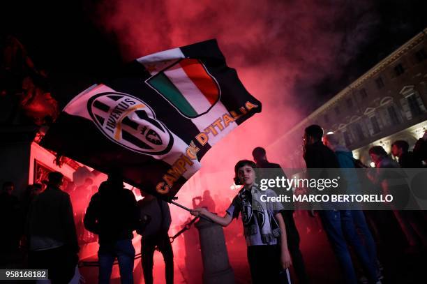 Juventus' supporters celebrate in central Turin after their team won a seventh straight Serie A title "scudetto" after a goalless draw against...