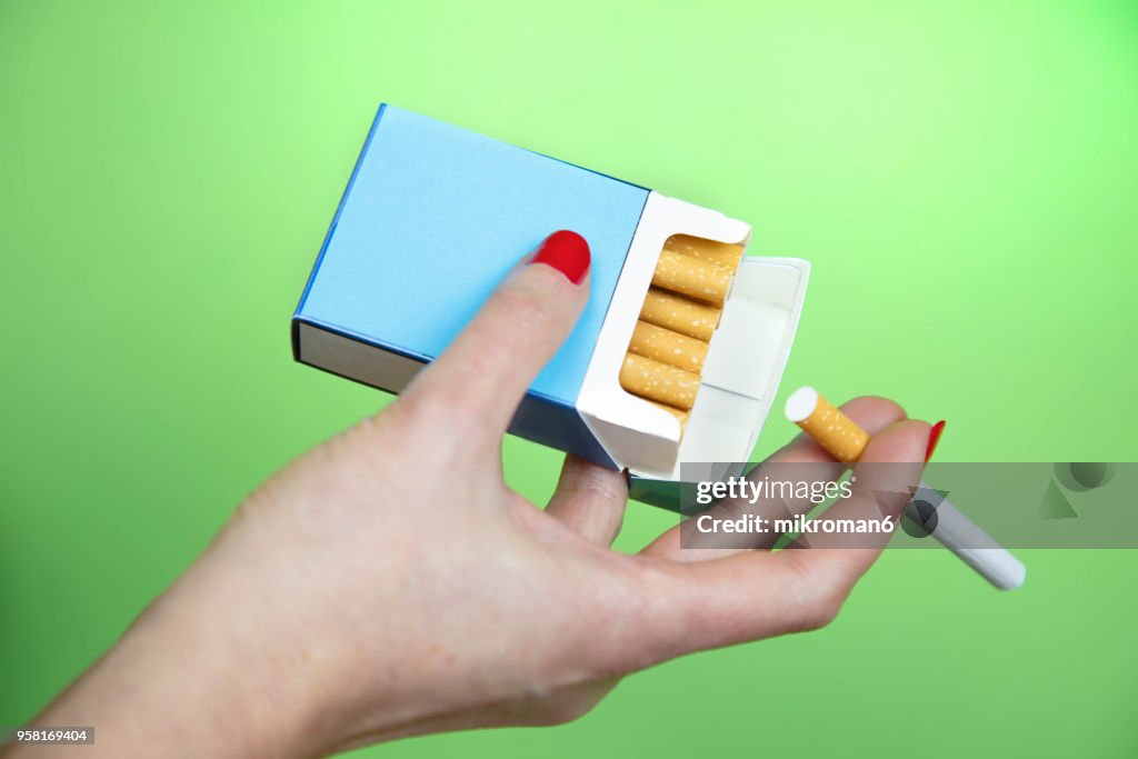 Woman's Hand taking cigarette from pack
