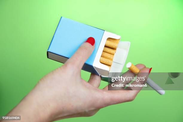 woman's hand taking cigarette from pack - cigarette stock pictures, royalty-free photos & images