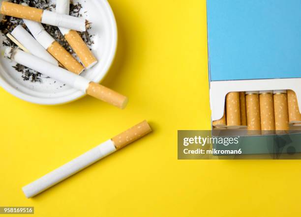 cigarettes and butts in ashtray - filtre de cigarette photos et images de collection