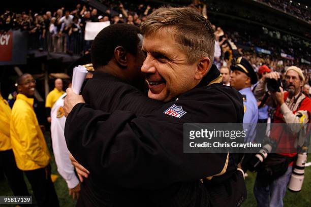 Head coach Sean Payton of the New Orleans Saints hugs Avery Johnson after their 45-14 win against the Arizona Cardinals during the NFC Divisional...