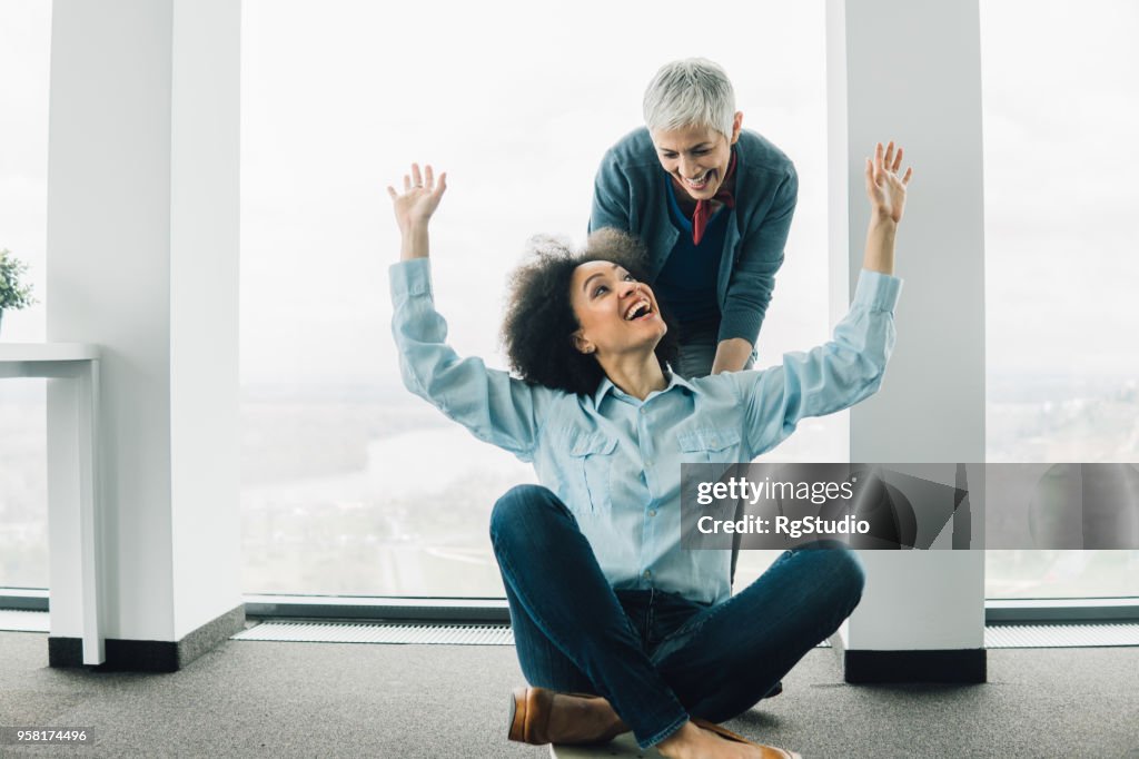 Young Business Woman And Mature Coworker Having Fun At Office High-Res ...