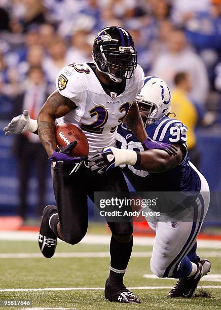 Willis McGahee of the Baltimore Ravens runs the ball as Antonio Johnson of the Indianapolis Colts looks to tackle him from behind in the first...