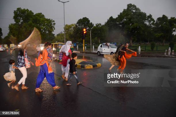 People rush to find shelter as a wind storm envelopes the national capital of Delhi bringing a sudden weather change on the eve of May 13, 2018 in...