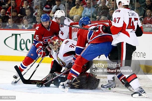 Mike Brodeur of the Ottawa Senators covers up the loose puck in front of Glen Metropolit and Travis Moen of the Montreal Canadiens during the NHL...