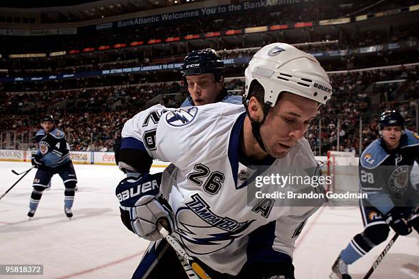 Martin St Louis of the Tampa Bay Lightning battles for the puck along the boards against Bryan Allen the Florida Panthers at the BankAtlantic Center...